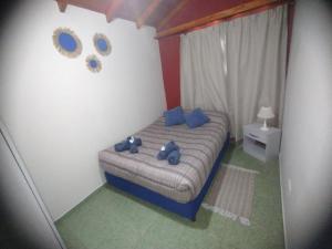 Un dormitorio con una cama con osos de peluche azules. en cabaña refugio junto al cerro, en San Luis 2 fotos más