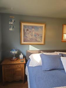 a bedroom with a bed and a picture on the wall at Against the Wind Vacation Rental LLC in Lake Leelanau