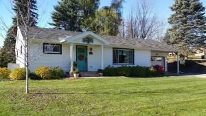 a house with a green door on a yard at Against the Wind Vacation Rental LLC in Lake Leelanau