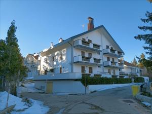 ein großes weißes Gebäude mit Balkon auf einer Straße in der Unterkunft Casa Zuzu in Ovindoli