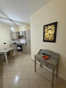 a living room with a table and a kitchen at Rama house in Caserta