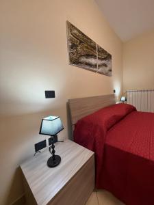 a bedroom with a bed and a lamp on a table at Rama house in Caserta