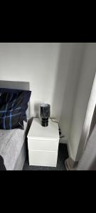 Een zwarte vaas staat op een nachtkastje naast een bed. bij Grove manor in Streatham Vale