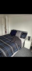 een slaapkamer met een bed met een blauw-witte deken bij Grove manor in Streatham Vale