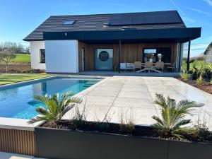 a home with a swimming pool and a house at Inspire Residence and private Wellness in Tongeren