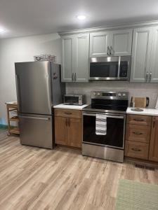 a kitchen with stainless steel appliances and wooden cabinets at Modern Nature Escape in Sparta
