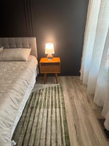 a bed with a table with a lamp on it at Modern Nature Escape in Sparta