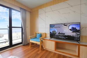 Una sala de estar con un televisor de pantalla plana grande. en 光隅民宿 Light Haus Inn, en Hengchun