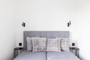 een slaapkamer met een groot bed met witte muren bij Varenastay in Varėna