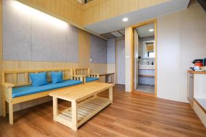 Habitación con sofá azul y mesa. en 光隅民宿 Light Haus Inn, en Hengchun