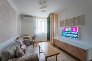 a living room with a couch and a tv at Spa & Relaxation 15 min de Lyon - Noomi Suite in Oullins