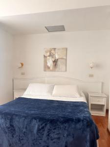 a bedroom with a bed with a blue blanket on it at Soggiorno Madrid in Florence