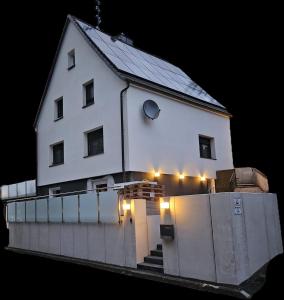 een wit huis met lichten op een hek bij FeWo Höhwald in Niederdorla