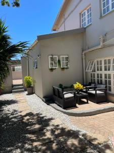 a house with black chairs and a patio at Gecko Units in Amsterdamhoek