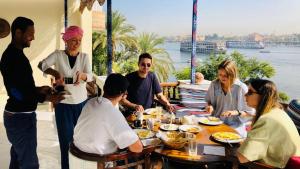 a group of people sitting around a table eating food at Nile Castle in Luxor