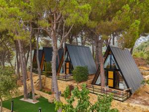 an image of a cabin in the woods with trees at Pine Straw Douma in Douma