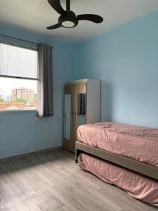 a bedroom with a bed and a ceiling fan at Badaró's Beach in Praia Grande