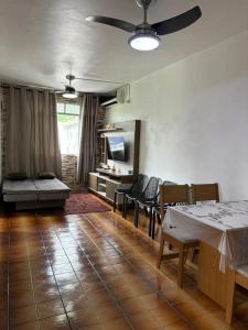a living room with a table and chairs and a tv at Badaró's Beach in Praia Grande