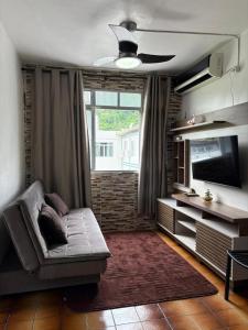 a living room with a couch and a large window at Badaró's Beach in Praia Grande +32 photos