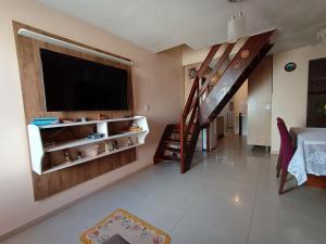 un soggiorno con TV a schermo piatto e scala di Sobrado em área tranquila a Caxias do Sul