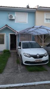 una macchina bianca parcheggiata di fronte a una casa di Sobrado em área tranquila a Caxias do Sul