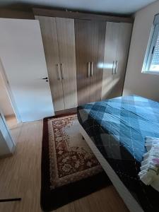 una camera con letto, armadi e tappeto di Sobrado em área tranquila a Caxias do Sul