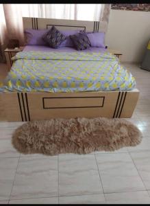 ein Schlafzimmer mit einem Bett und einem Teppich auf dem Boden in der Unterkunft Osprise Residencies in Tema