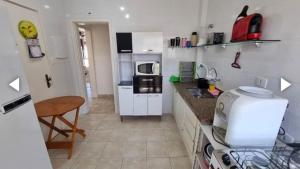 グアルジャにあるPraia de Pitangueirasの白いキャビネットとカウンタートップを備えたキッチン