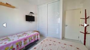 グアルジャにあるPraia de Pitangueirasのベッドとテレビと窓のある寝室 +6枚の写真