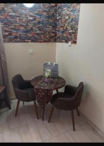einen Tisch in einem Zimmer mit 2 Stühlen und einem Tisch mit in der Unterkunft Osprise Residencies in Tema + 2 Fotos