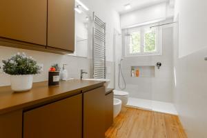 Un baño con lavabo, inodoro y ventana. en Milan - Refuge in the Green, en Cusano Milanino 110 fotos más