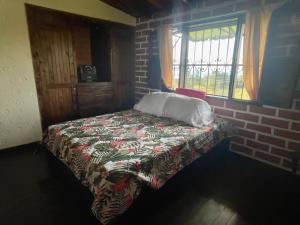 メデジンにあるSerene Soul Arroyaveのレンガの壁のある部屋にあるベッド
