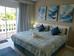 a bedroom with a bed with blue pillows and a window at Gecko Units in Amsterdamhoek +59 photos