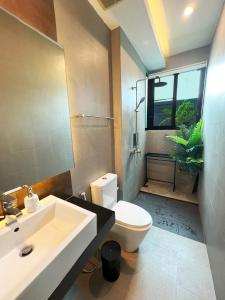 een badkamer met een wastafel en een toilet en een raam bij Intimate Oasis, 2 bedrooms Pool in Kata Beach
