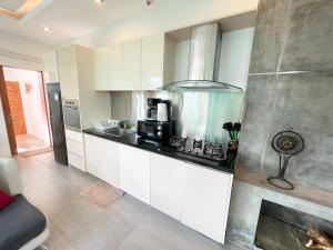 een keuken met witte kasten en een kookplaat oven bij Intimate Oasis, 2 bedrooms Pool in Kata Beach