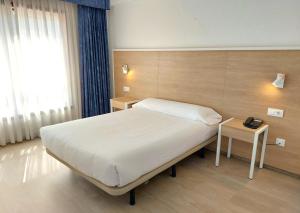 Hotel Costa Atlántica في أرتيكسو: غرفة فندق بها سرير ونافذة