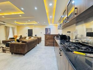 a large living room with couches and a kitchen at StayatMargarets in Abuja