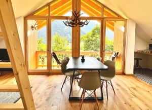 Alpen Lodge in Osterhofen - Berge, Ruhe & Natur في بايريشزيل: غرفة طعام مع طاولة وكراسي ونافذة كبيرة
