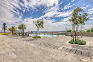 a patio with benches and trees under a cloudy sky at Bella Vista at Ellipse in Midrand