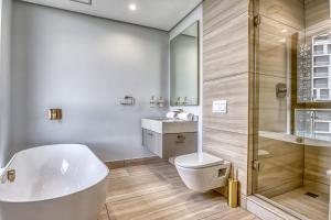 a bathroom with a tub and a toilet and a shower at Bella Vista at Ellipse in Midrand +9 photos