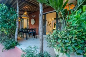 a patio with a table and chairs and plants at Maison de clara in Ngaparou
