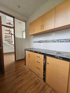 Una cocina vacía con armarios de madera y una escalera. en Puente de Gocta, en Cocachimba
