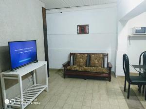 un soggiorno con una tv e un letto di Departamento Monte Caseros a Monte Caseros Altre 4 foto