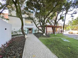 a brick walkway in front of a building with trees at Flat Premium no Centro de Porto de Galinhas - Próximo as piscinas naturais in Porto De Galinhas