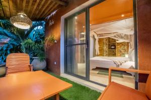 una habitación con una cama y una mesa y una ventana en Maison de clara, en Ngaparou