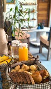 Suíte Alvorada Tiradentes MG في تيرادينتيس: سلة من الخبز وعصير البرتقال على الطاولة +20 صورة