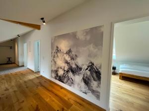 Alpen Lodge in Osterhofen - Berge, Ruhe & Natur في بايريشزيل: غرفة نوم مع لوحة كبيرة على الحائط