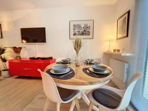 a dining room with a wooden table and chairs at Appartement centre Orsay in Orsay