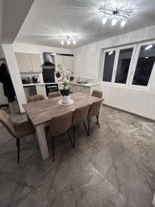 a kitchen and dining room with a wooden table and chairs at Maison Relax Spa & tranquillité in Auberchicourt