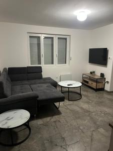 a living room with a couch and two tables at Maison Relax Spa & tranquillité in Auberchicourt